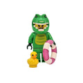 Toy figure of a green creature with a pink life preserver and yellow duck on a white background