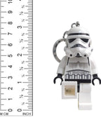 LEGO Stormtrooper keychain with a small square object next to a ruler for scale on a white background